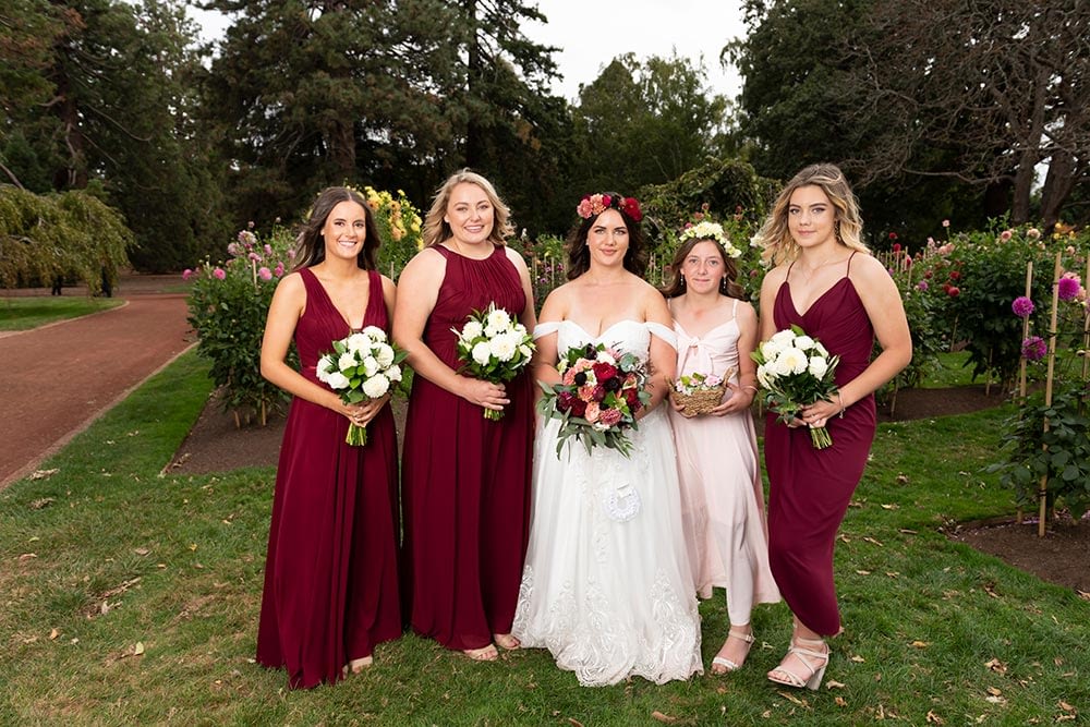 bride , bridesmaids and flowers after wedding ceremony