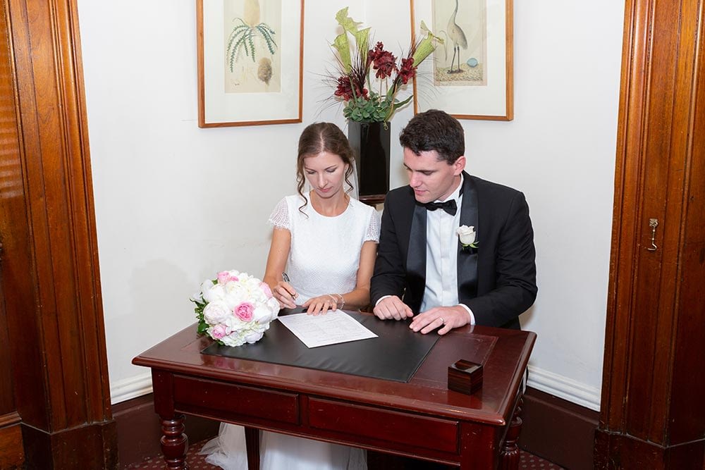 bride and groom signing wedding certificate at wedding ceremony