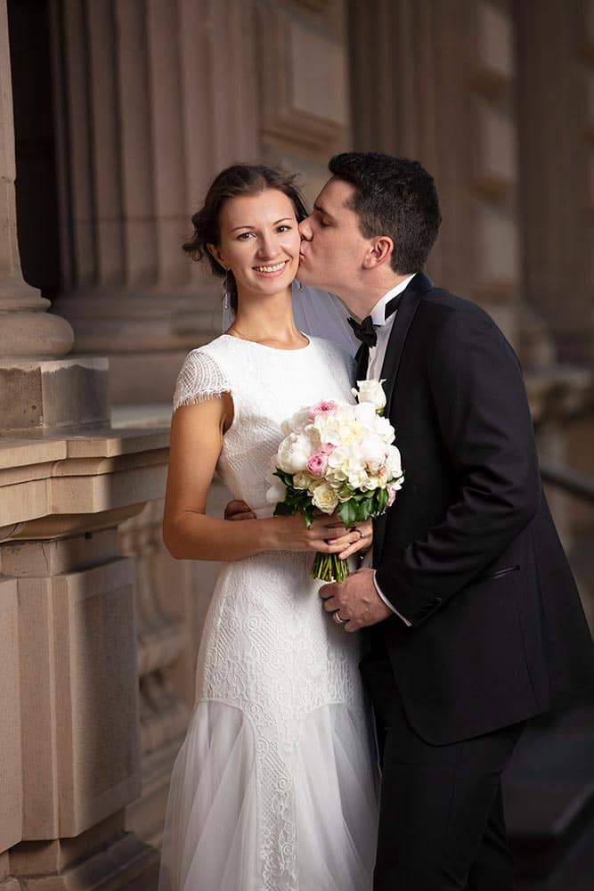 a groom kiss his bride at old treasury building